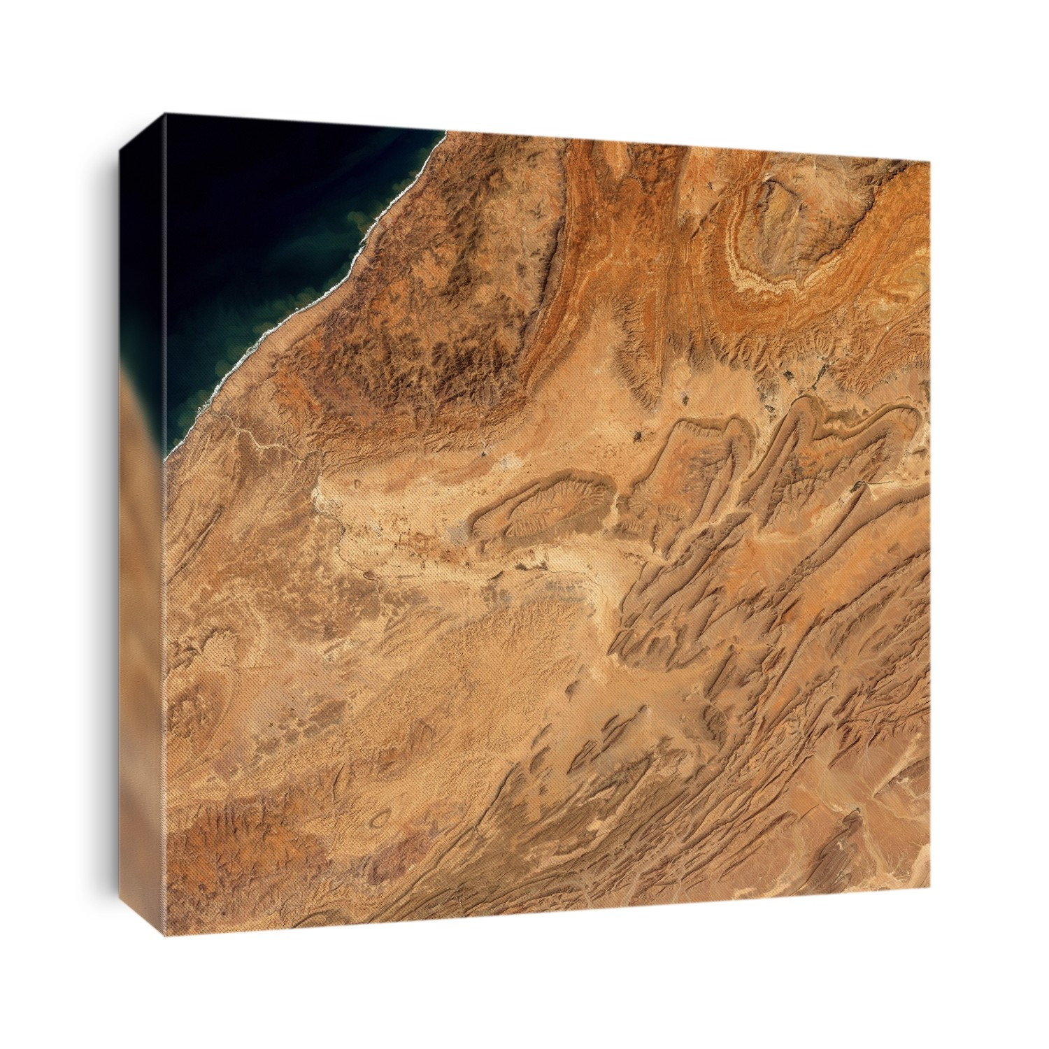 Anti-Atlas mountains, Morocco, satellite image. North is at top. This image covers an area around 70 kilometres across, and shows the south-western end of the Anti-Atlas Mountains. Most of the landscape consists of eroded mountains and rock structures called mesas (centre), and narrower mountain ridges (lower right). The landscape has formed over millions of years of erosion. Most of the landscape is a barren desert, but centre-pivot irrigation and agriculture occurs in the valley of the river flowing from centre to the Atlantic coast at upper left. At centre left, just to the left of one of the large mesas, is the city of Guelmine (grey). Image obtained on 19 March 2002 by the ETM+ sensor on the Landsat 7 satellite.