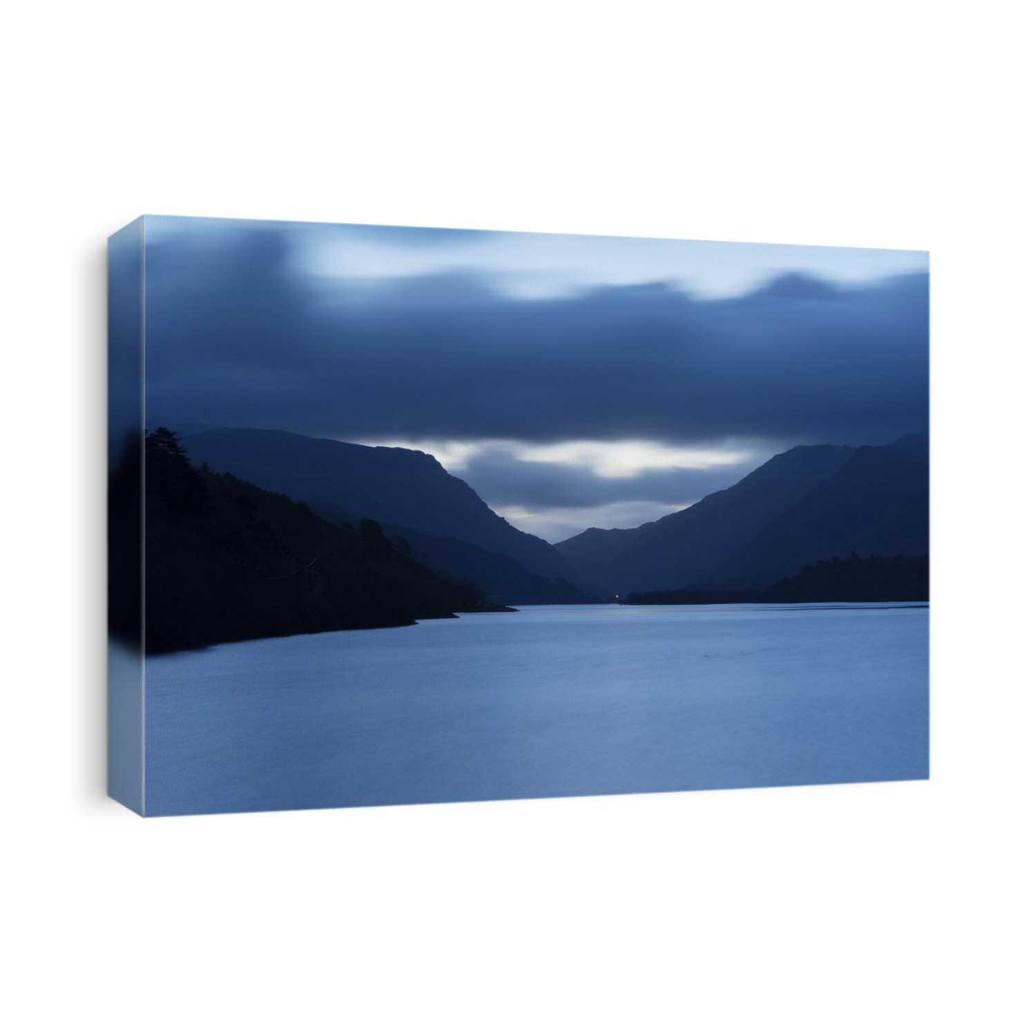 Llyn Padarn and the Llanberis Pass, Snowdonia, Wales, UK. Llyn Padarn is a glacially formed lake and is an example of a moraine dammed lake. It is approximately 3.2 kilometres long 29 metres deep, and it is one of the largest natural lakes in Wales. In the distance is the Llanberis Pass, bounded by the Glyderau mountains (left) and the Snowdon massif (right).