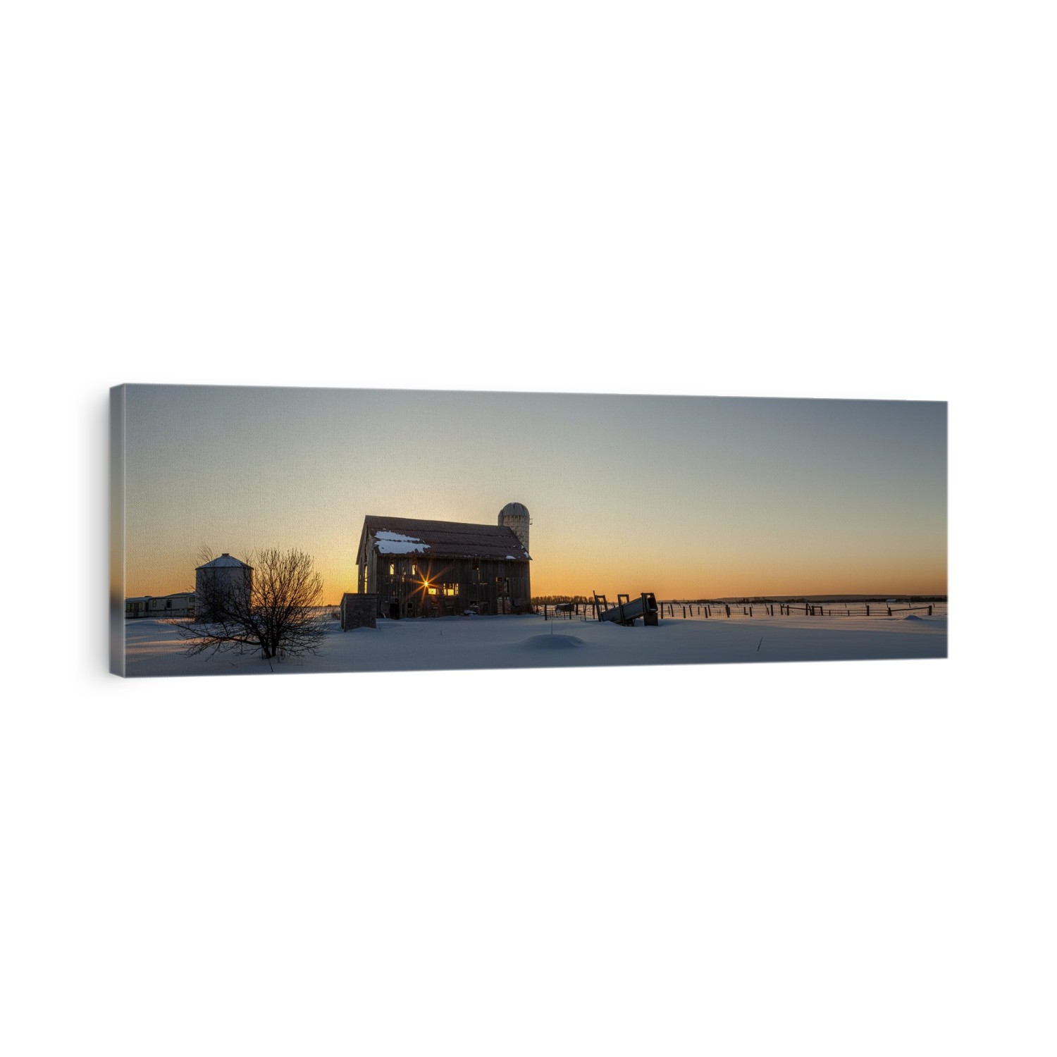 Dilapidated bard at sunrise in winter with a glowing yellow sky over the horizon seen through the abandoned barn; Rudyard, Michigan, United States of America