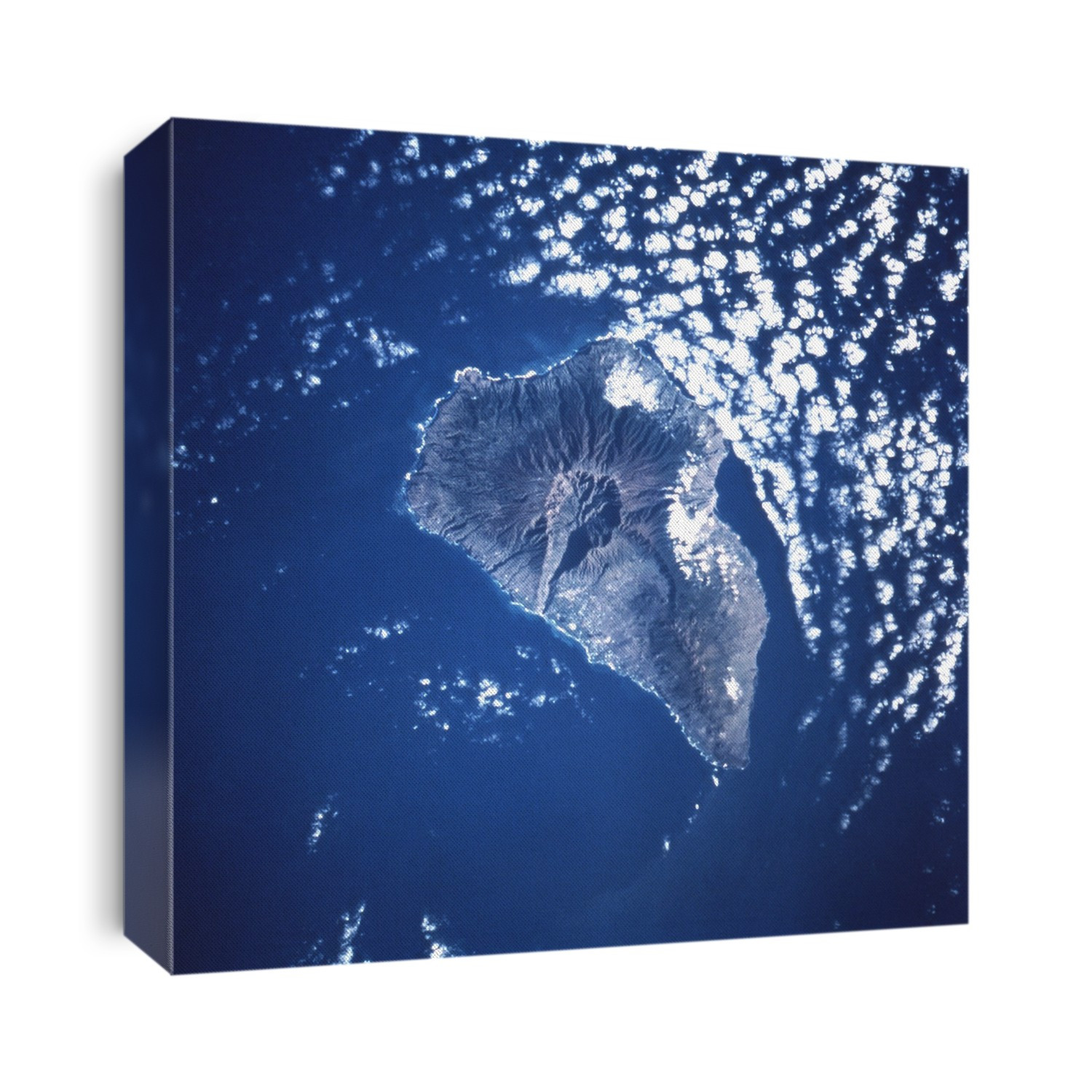 La Palma. Space Shuttle image of the volcanic island of La Palma, largest of the western Canary Islands, in the Atlantic Ocean (blue). North is at top left. Clouds are scattered at upper right. It is thought that a future volcanic eruption, within the next few thousand years, could cause the western half of the island to collapse into the sea. The impact of 500 billion tonnes of rock would create a mega-tsunami, a massive wave of water. This would cross the Atlantic Ocean within hours, swamping the islands of the Caribbean Sea and devastating the eastern coast of the USA, travelling up to 20 kilometres inland.