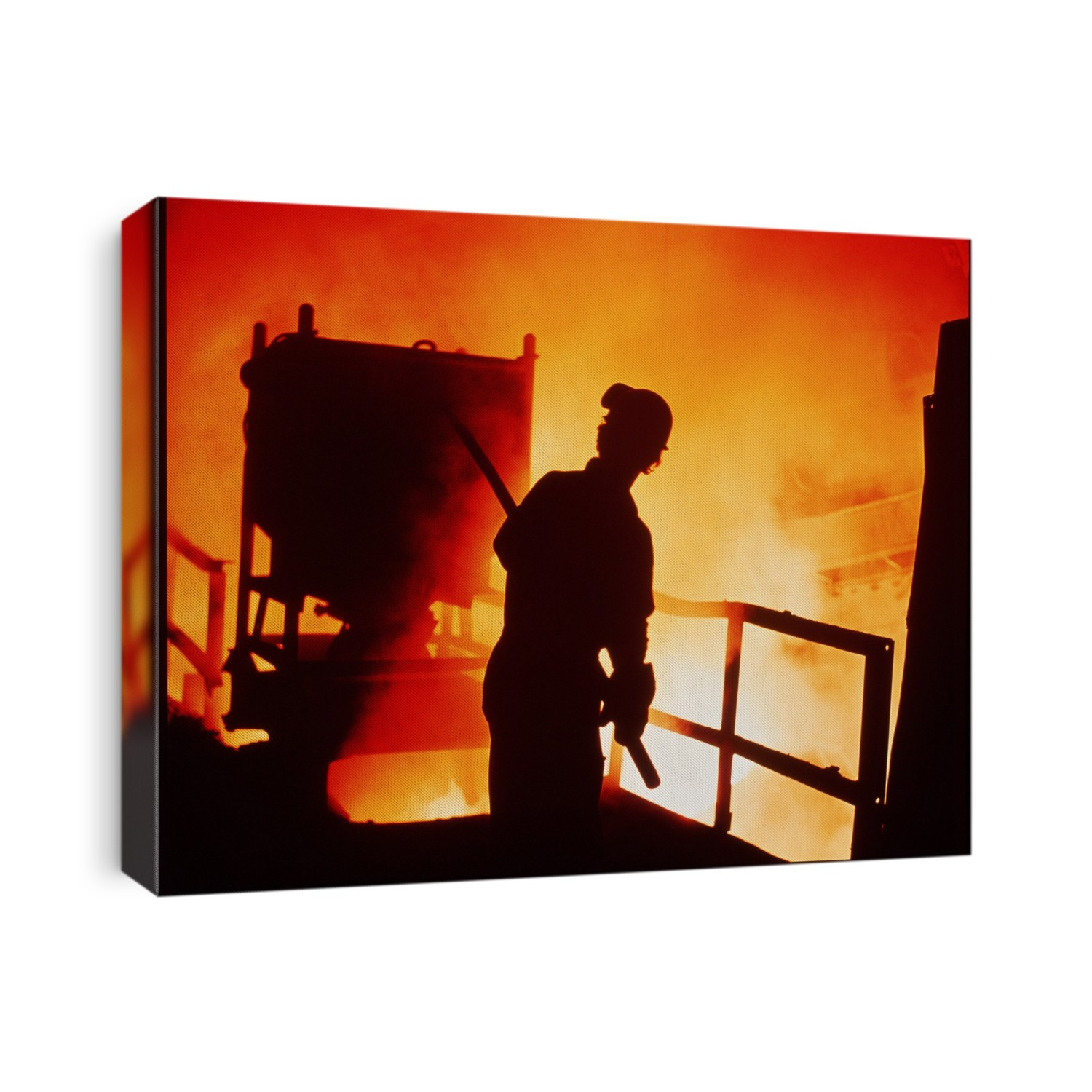 Silhouette of a foundryman against the orange glow of molten steel at British Steel's Rothermere plant, Sheffield, England.