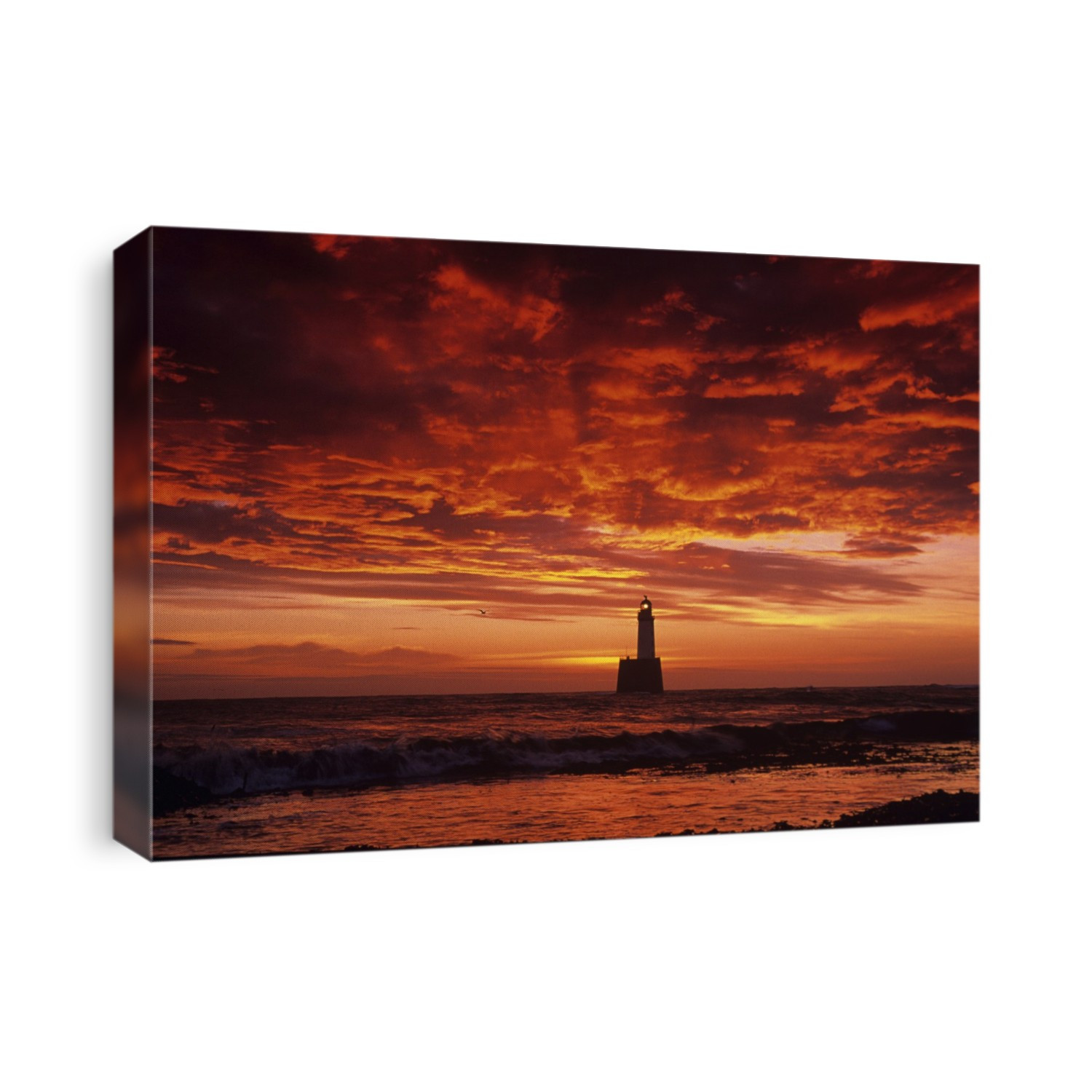 Red sky and clouds at sunrise over Rattray Head lighthouse near Peterhead, Grampian, UK. Photographed in November.