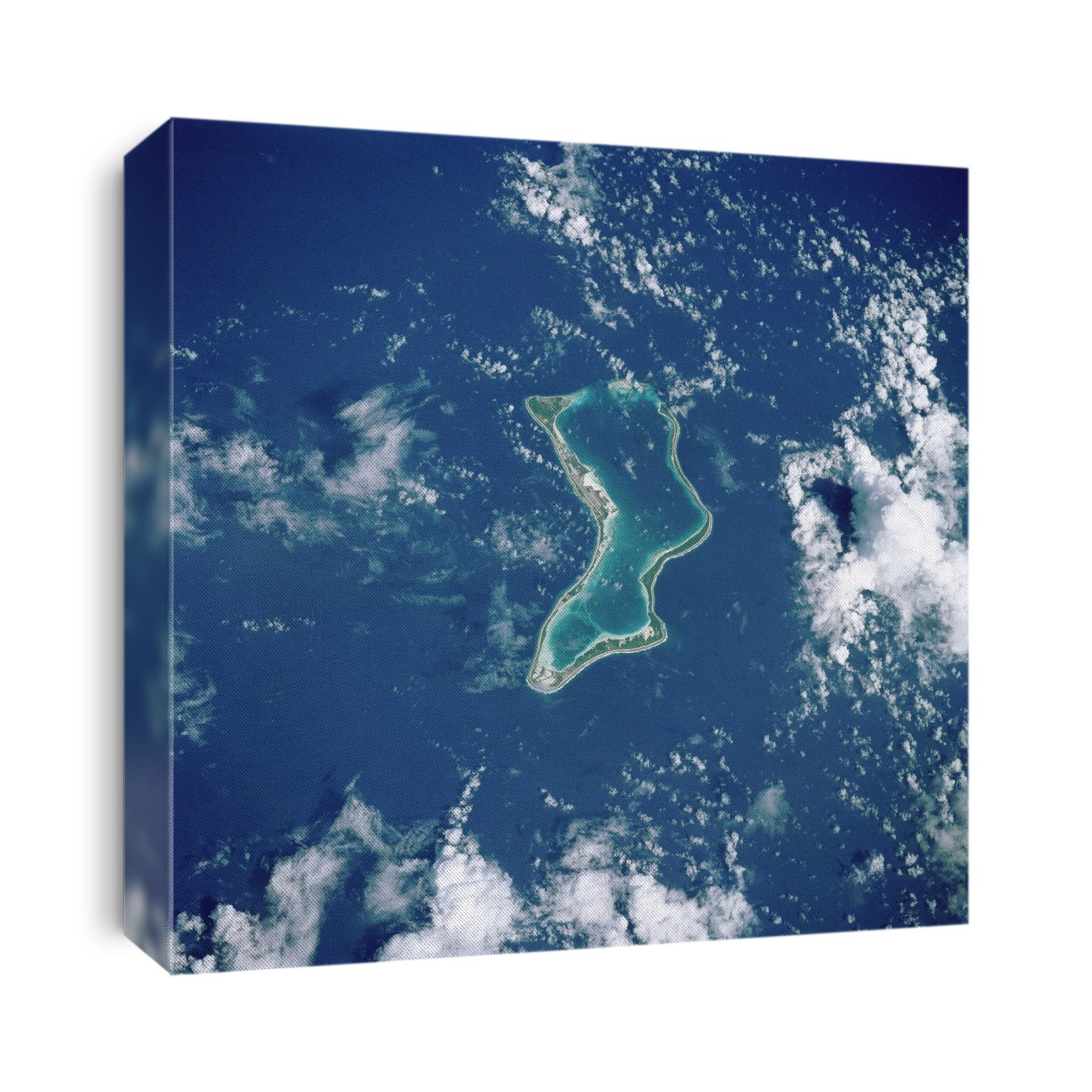 Diego Garcia coral atoll, seen from the Space Shuttle Atlantis. The atoll (dark green) encloses the shallow water of a lagoon (pale green). Clouds are white and the sea is blue. Diego Garcia is the largest of the coral atolls of the Chagos Archipelago, which lies about 560 kilometres south of the Maldive Islands in the Indian Ocean. Coral reefs are formed by colonies of microscopic organisms on rocks just below the surface of the water. Wind-borne sediments can be deposited to form solid land where vegetation can establish itself. A large Anglo-American military base is in the north-west part of the atoll. Photographed on mission STS-038 (15-20 November 1990).