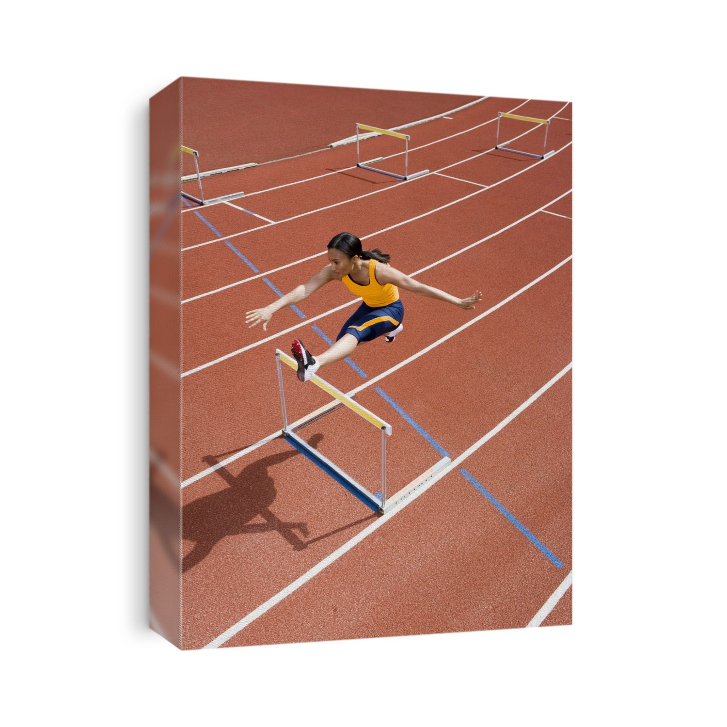 MODEL RELEASED. Athlete jumping over a hurdle on a race track. In athletics hurdling is a track and field event. The hurdles are obstacles that the athletes jump over while sprinting down the race track. It is an event that requires both speed and excellent technique.