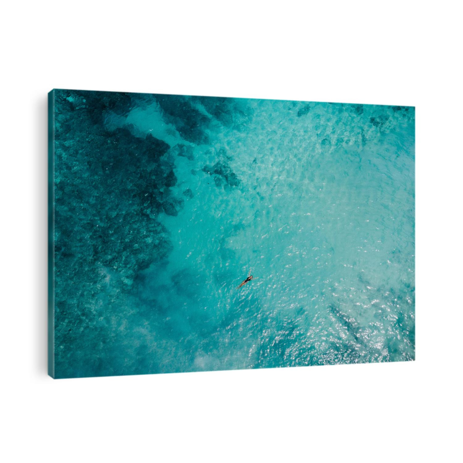 Aerial view woman in lack  bikini lying on transparent turquoise water surface on beach/ Vacation and adventure. Turquoise water. Top view from drone at ocean, azure water and relax girl