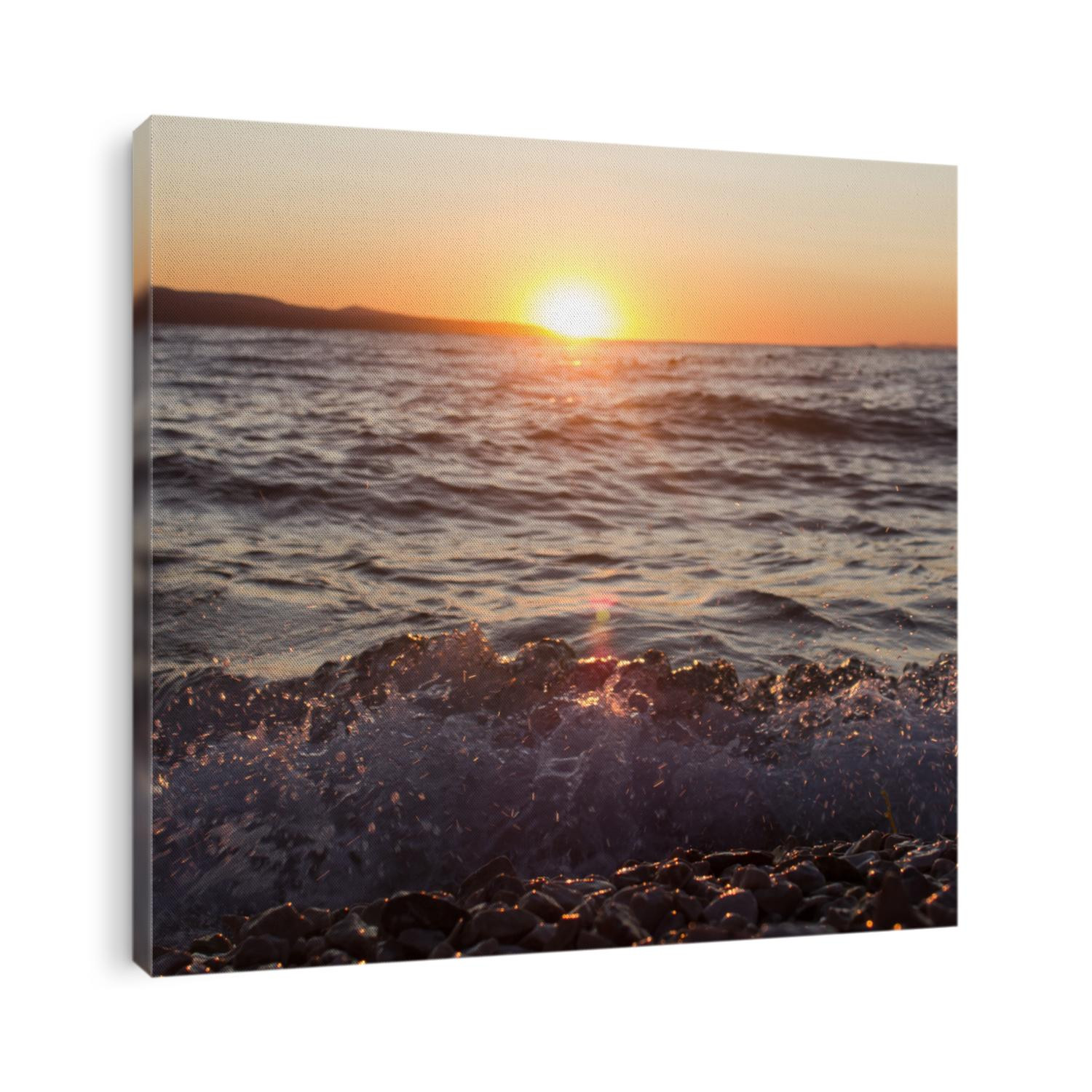 Nice yellow sunset on beach. Sea sunset with waves and shore. Beautiful sky colors and clouds. Sunset light reflecting on sea surface. 