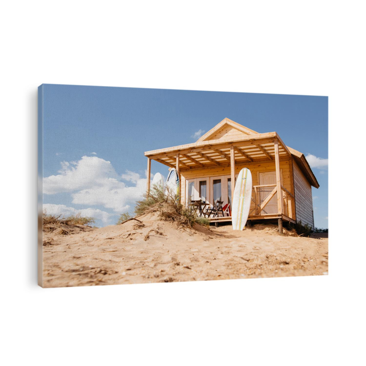 Holiday house on the beach. Wooden house with boards for wind serfing on a sand beach. Summer vacation concept.