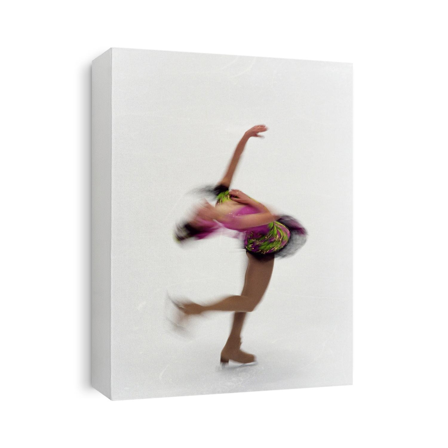Blured action of female figure skater preforming a spin.