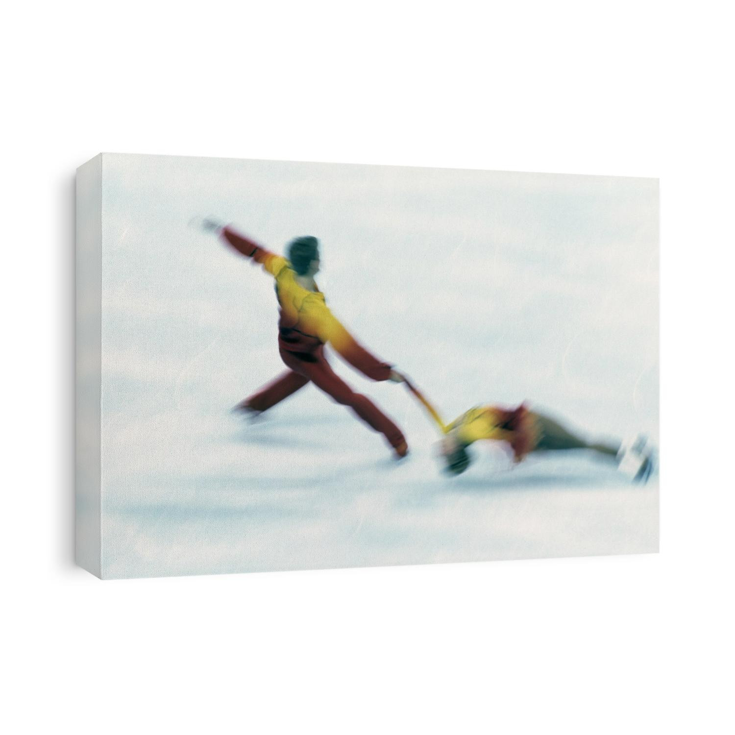 Blured action of pairs figure skaters preforming a death spiral.