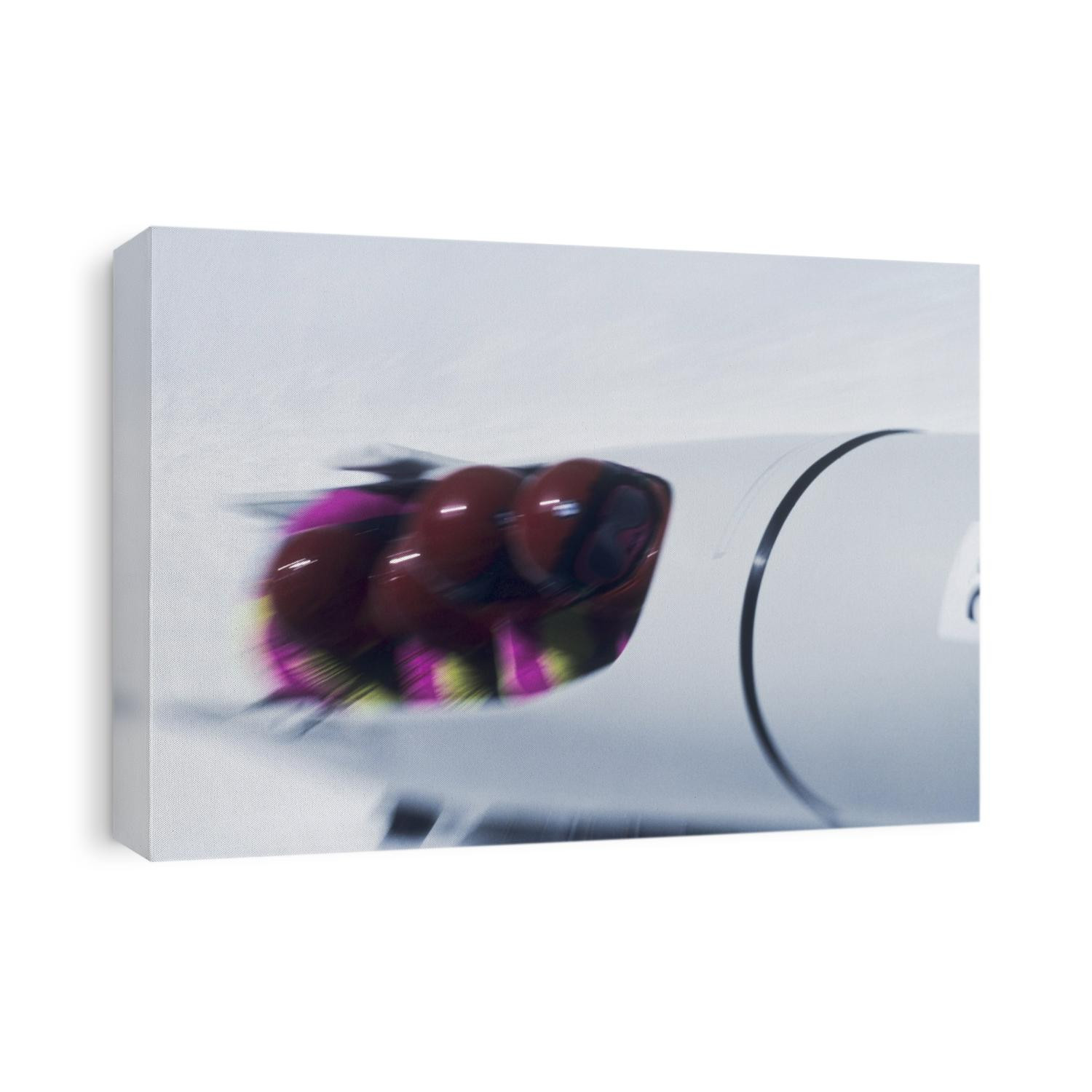 Blurred action of 4 man bobsled team.