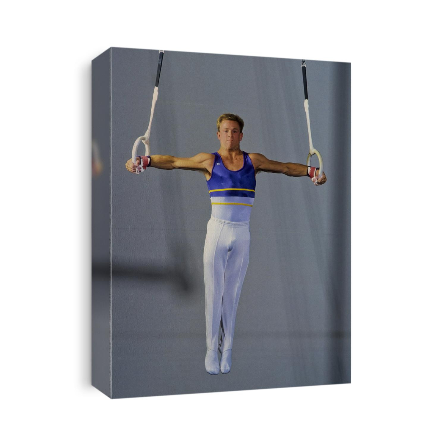 Male gymnast performing on the rings.