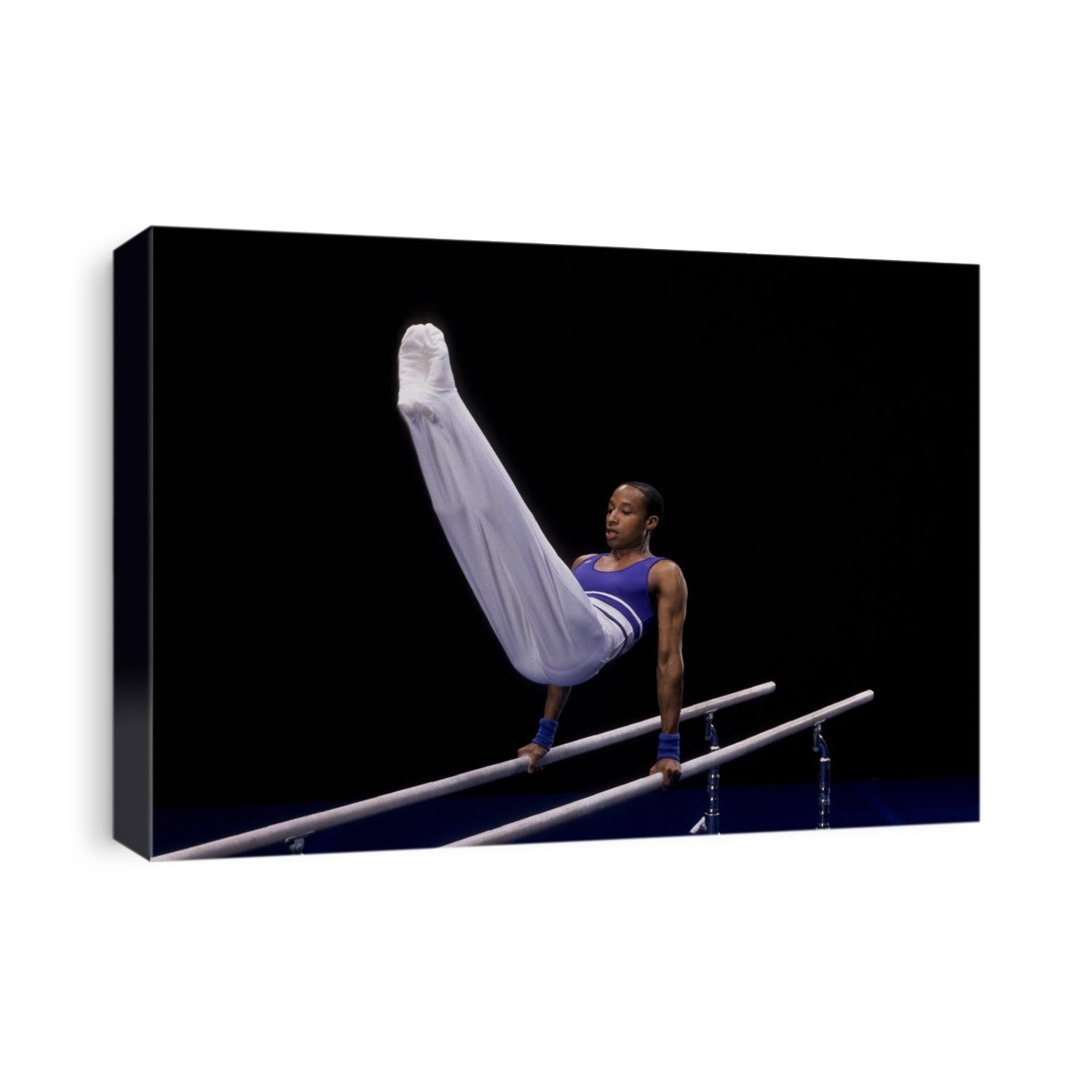 Male gymnast on the parallel bars.