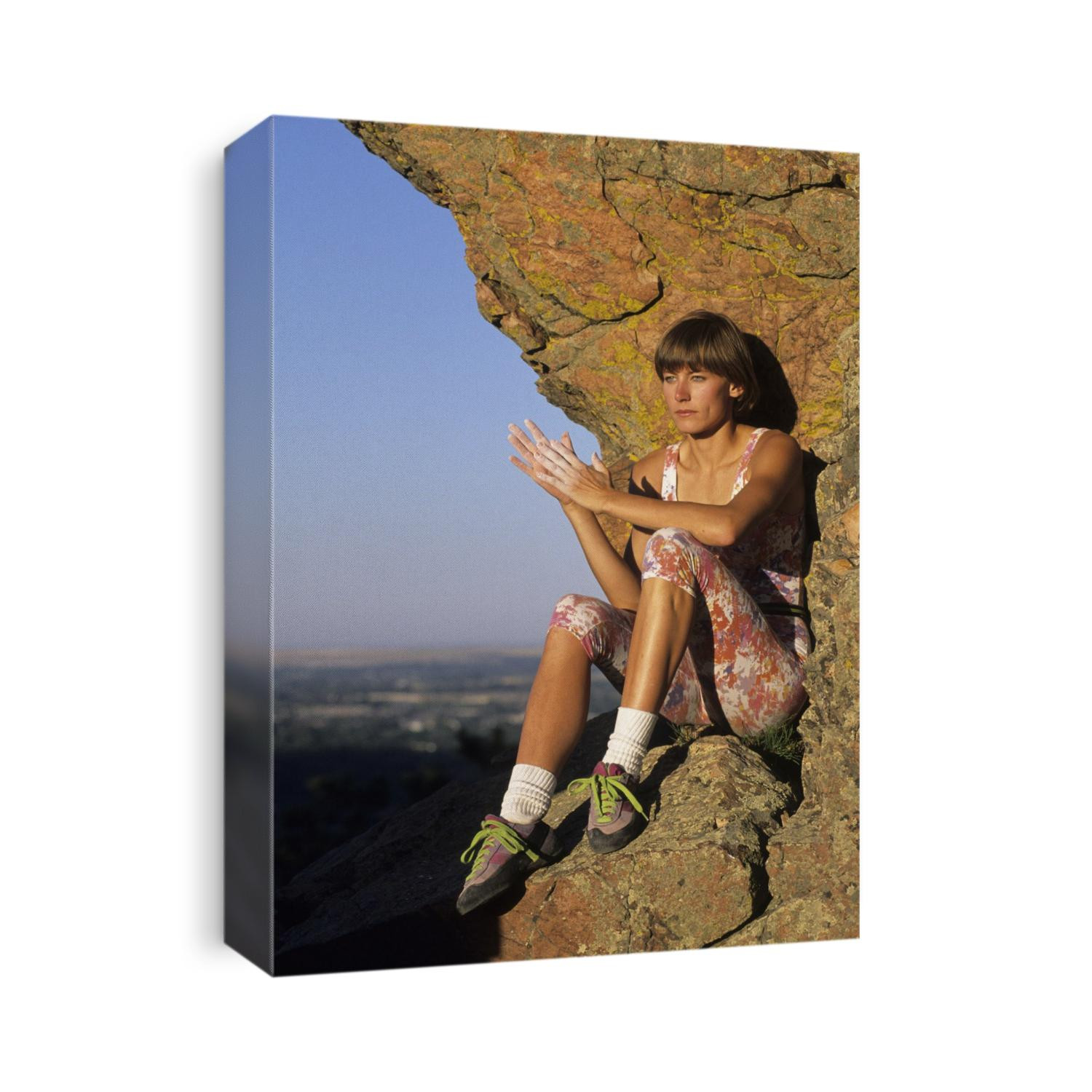 Woman climber resting on rock ledge.
