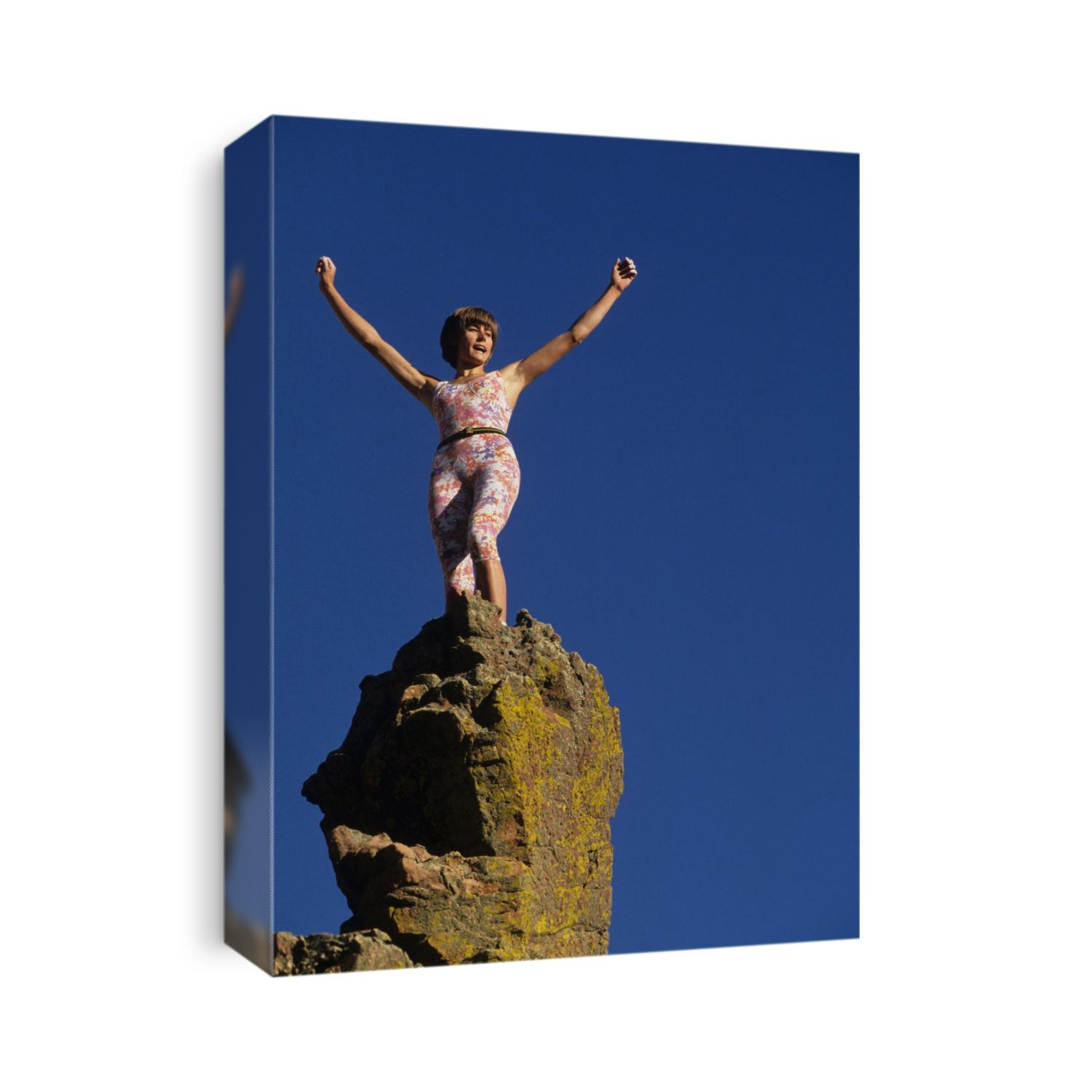 Young woman celebrates completing a successful climb.