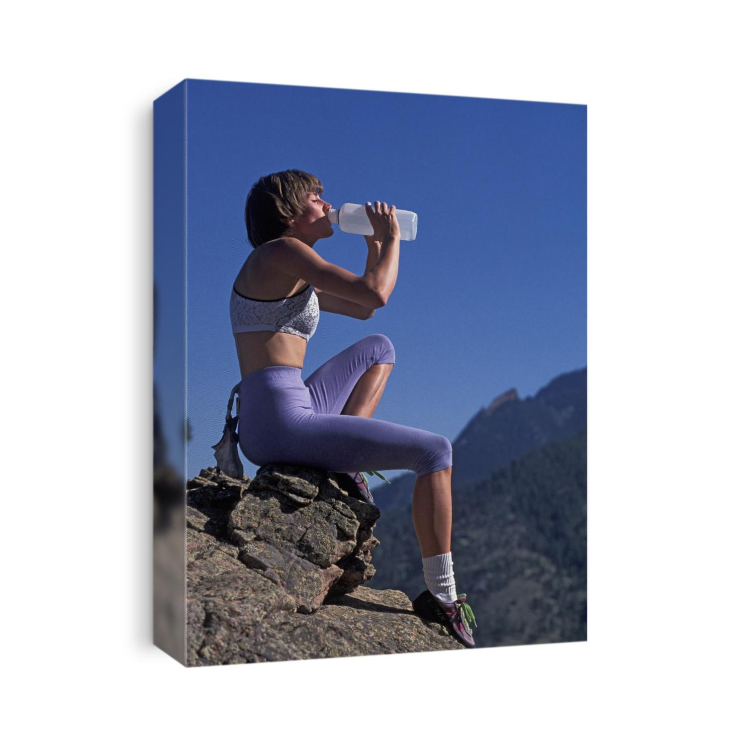 Woman rock climber drinking during a rest break.