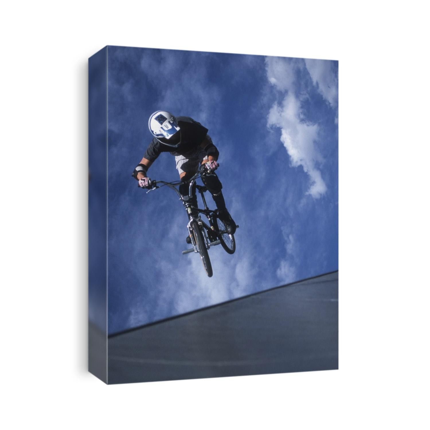 Teenage boy flys over the vert on a BMX bike.