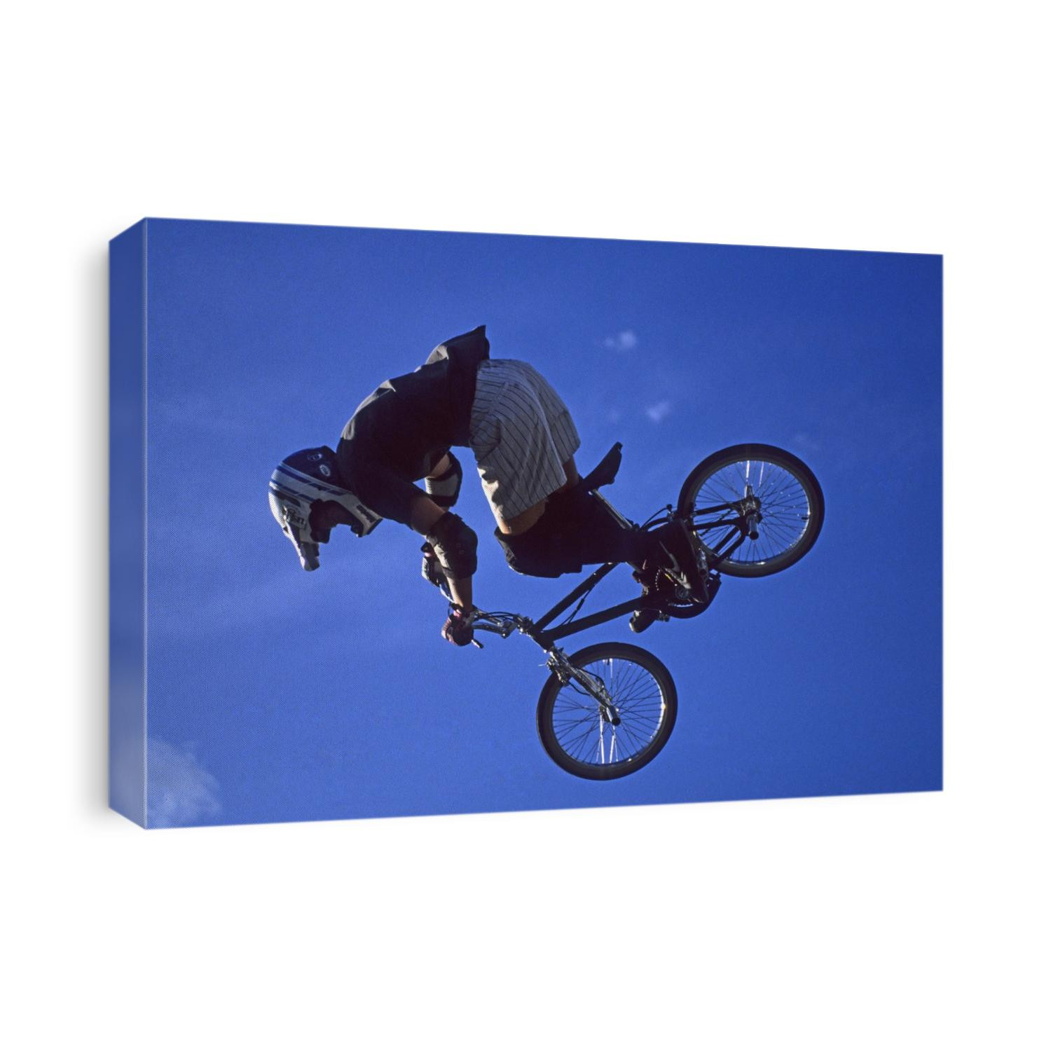 BMX cyclist flys over the vert.