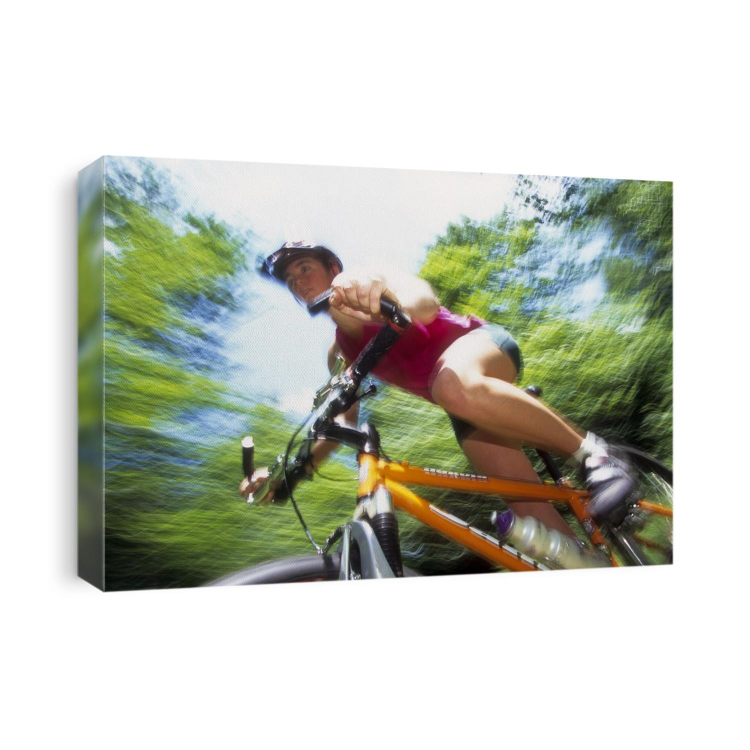 Young female recreational mountain biker riding in the forest.