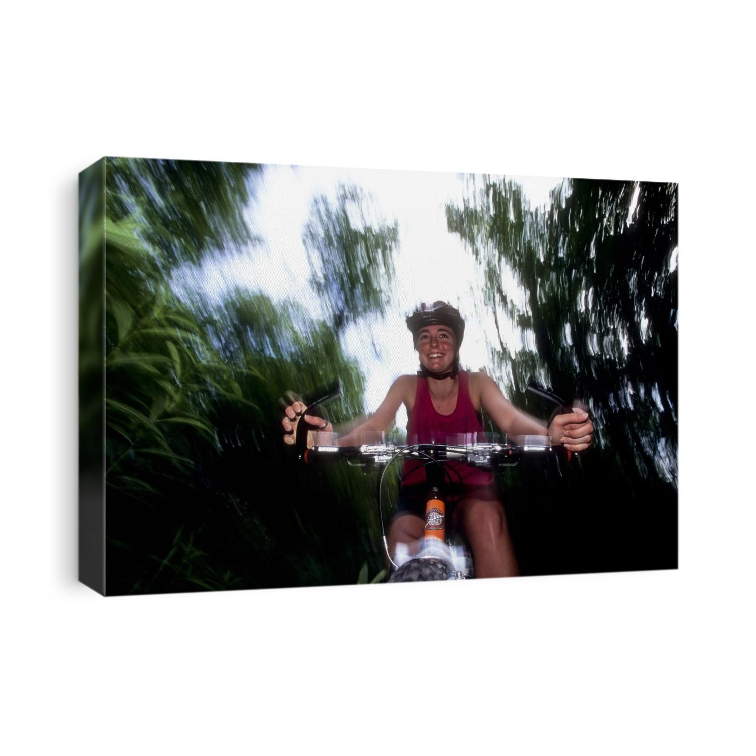 Young female recreational mountain biker riding in the forest.