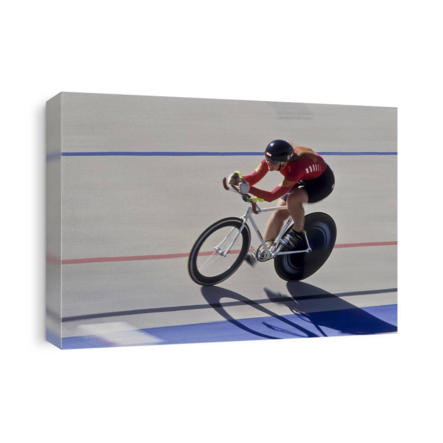 Femalre cyclist racing on the velodrome track.