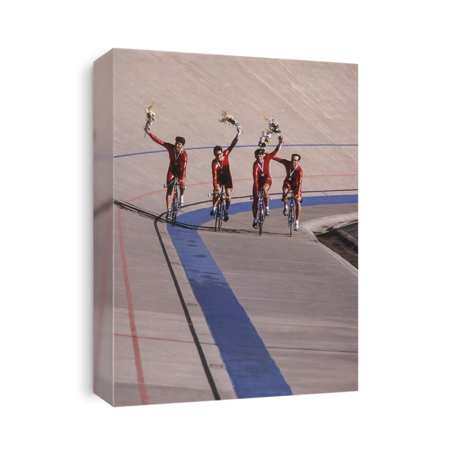 Victorious male cycling team on the velodrome.