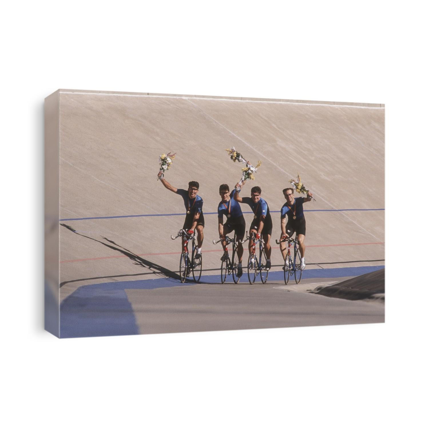 Victorious male cycling team on the velodrome.