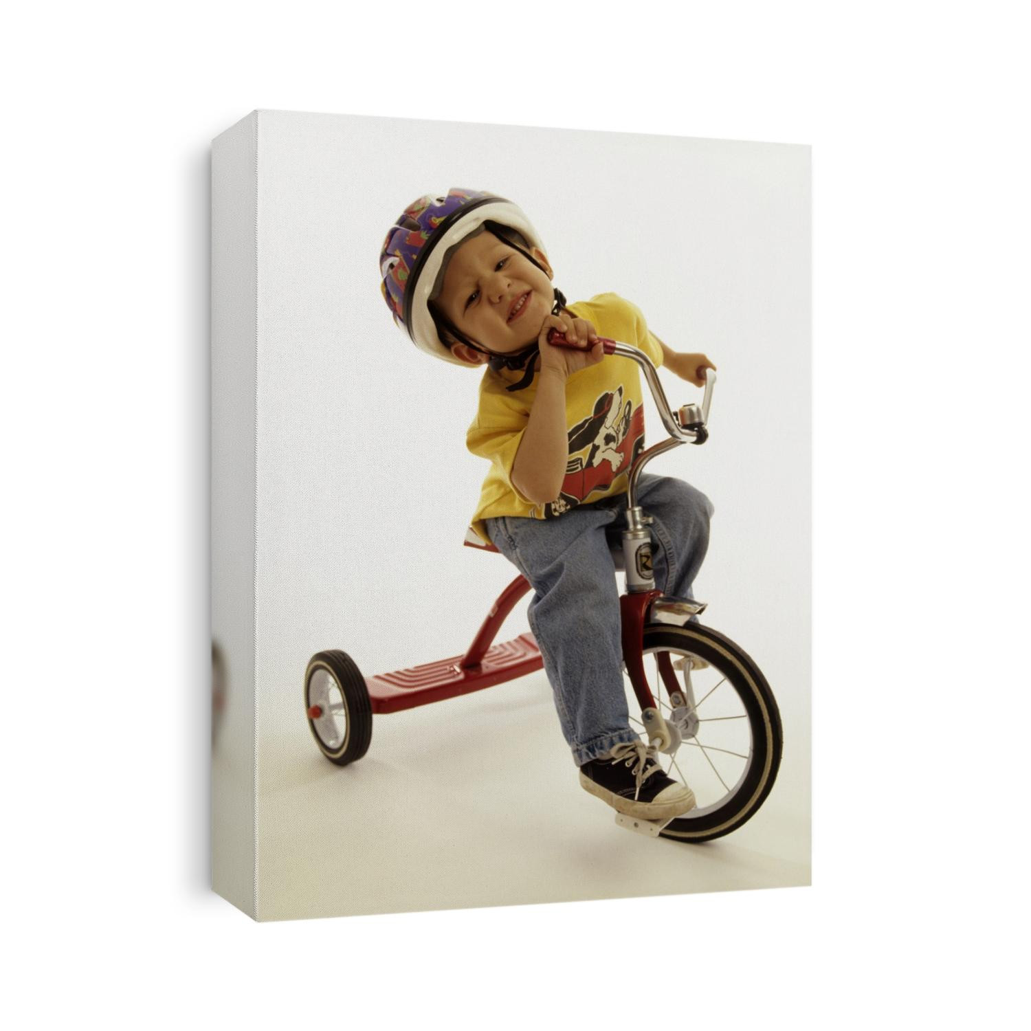 4 year old boy posing on his tricycle.