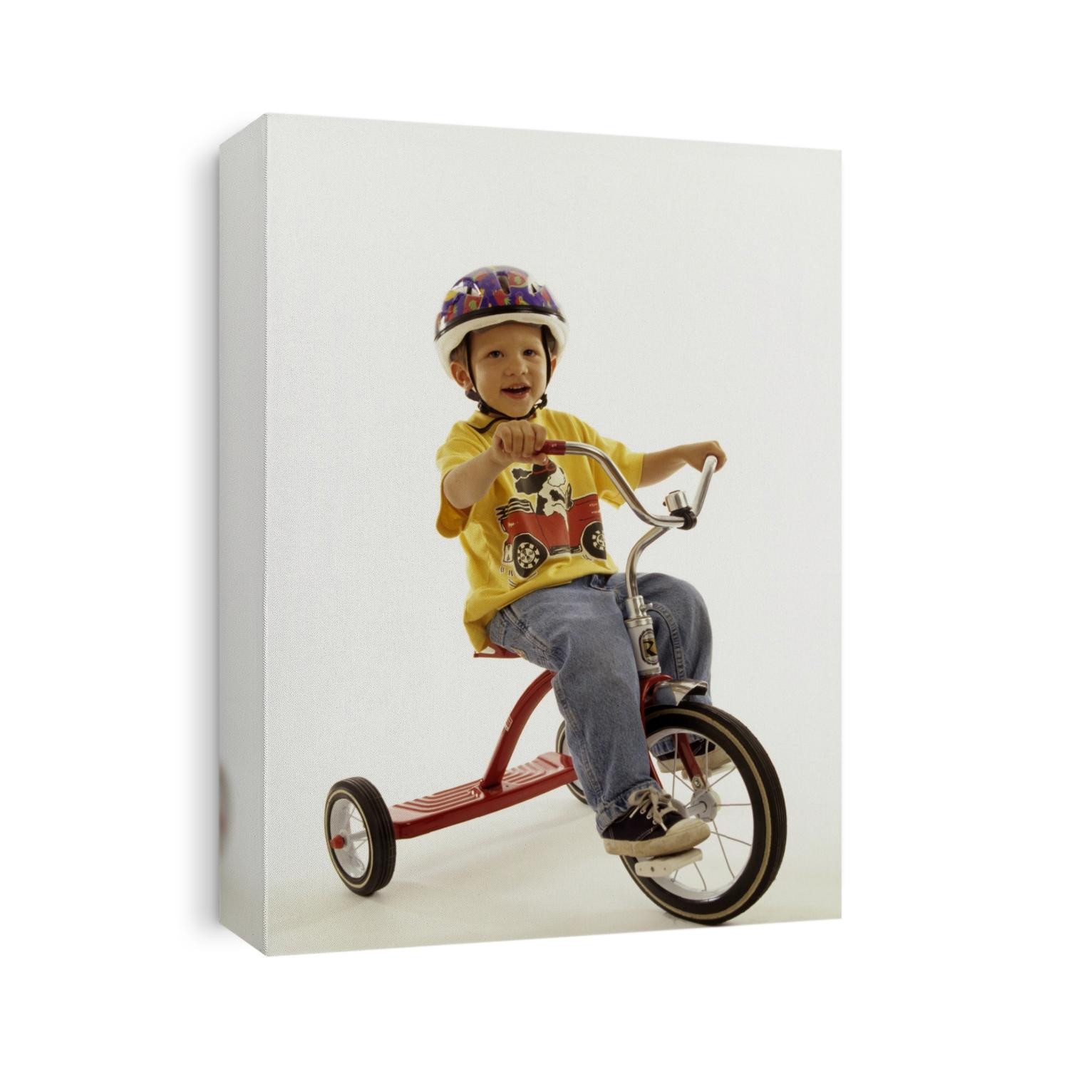 4 year old boy posing on his tricycle.