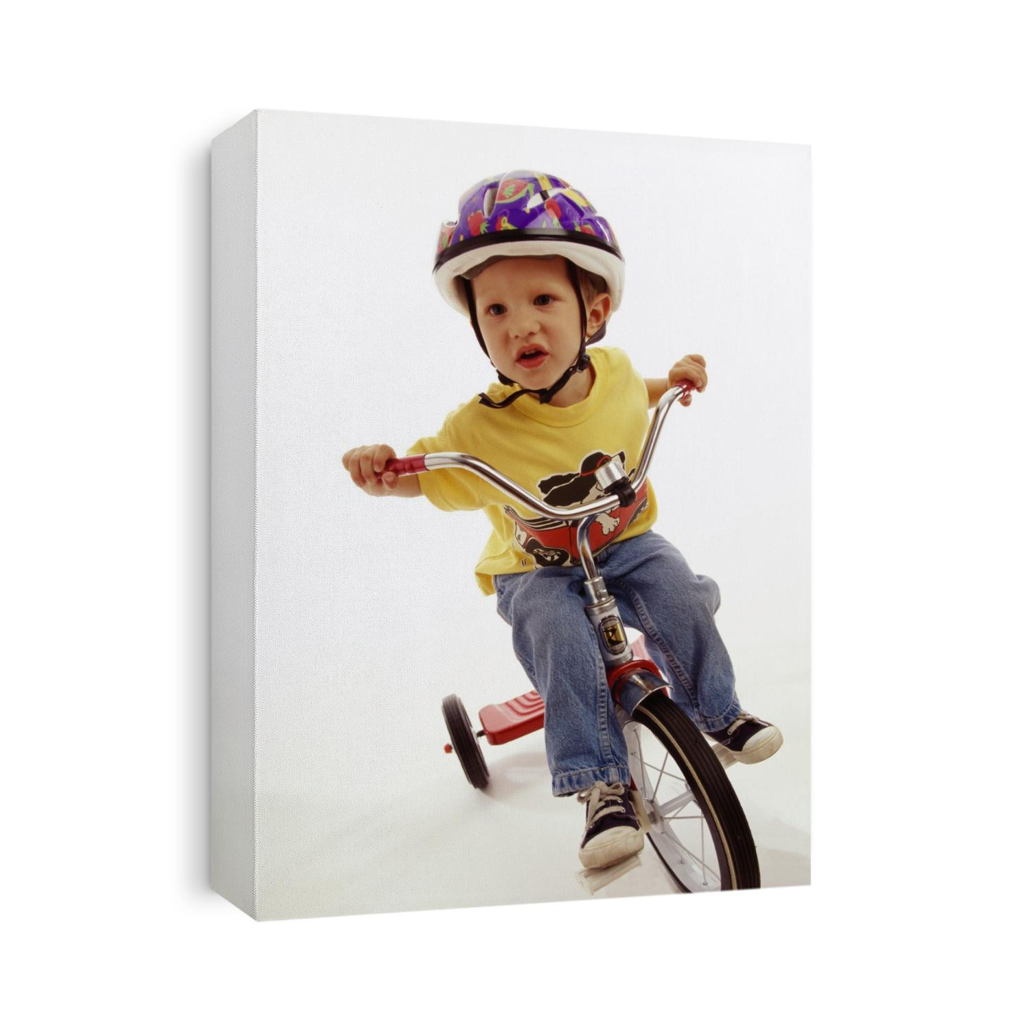4 year old boy posing on his tricycle.