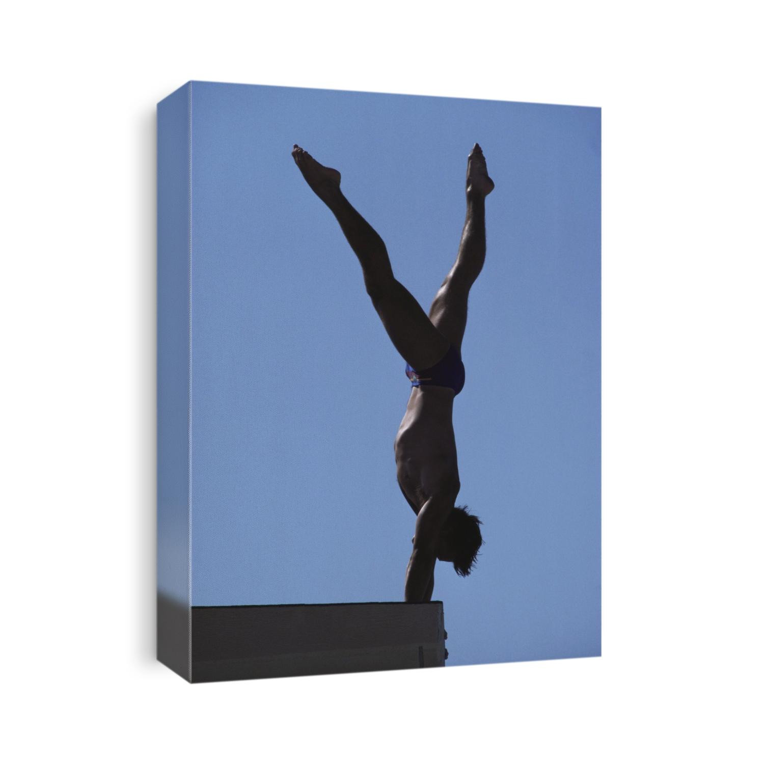 Silhouette of male diver on platform.