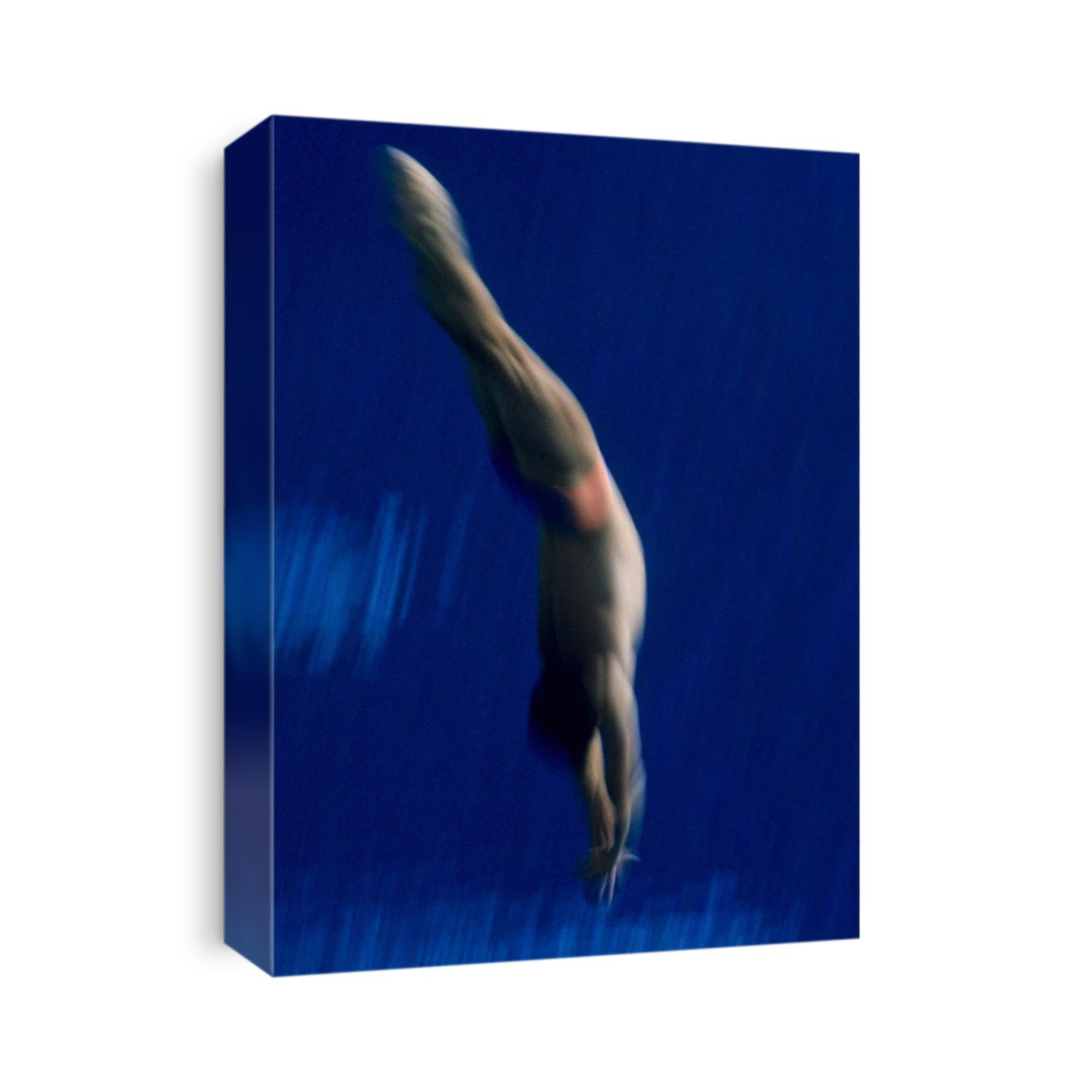 Blurred action of male diver in the air.