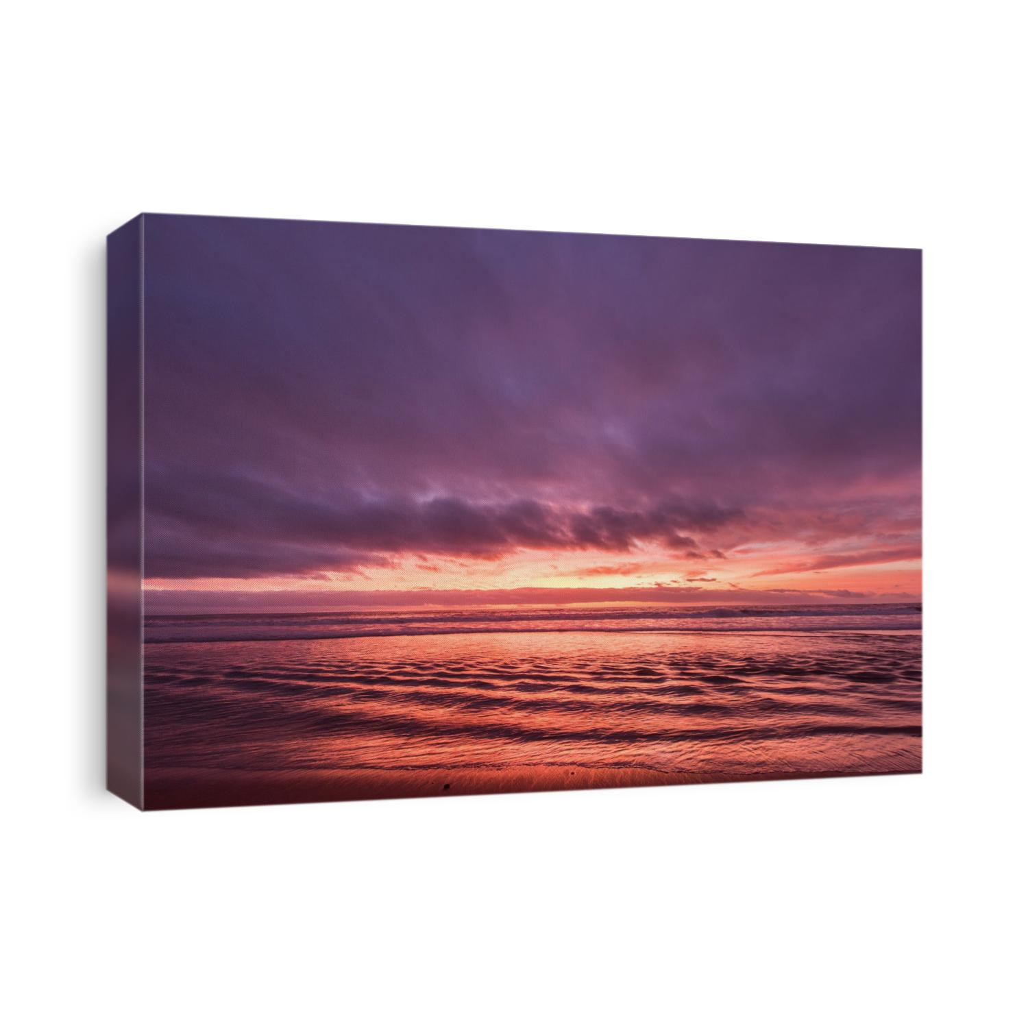 The colorful sunset reflects off the ripples shown at low tide in Hermosa Beach