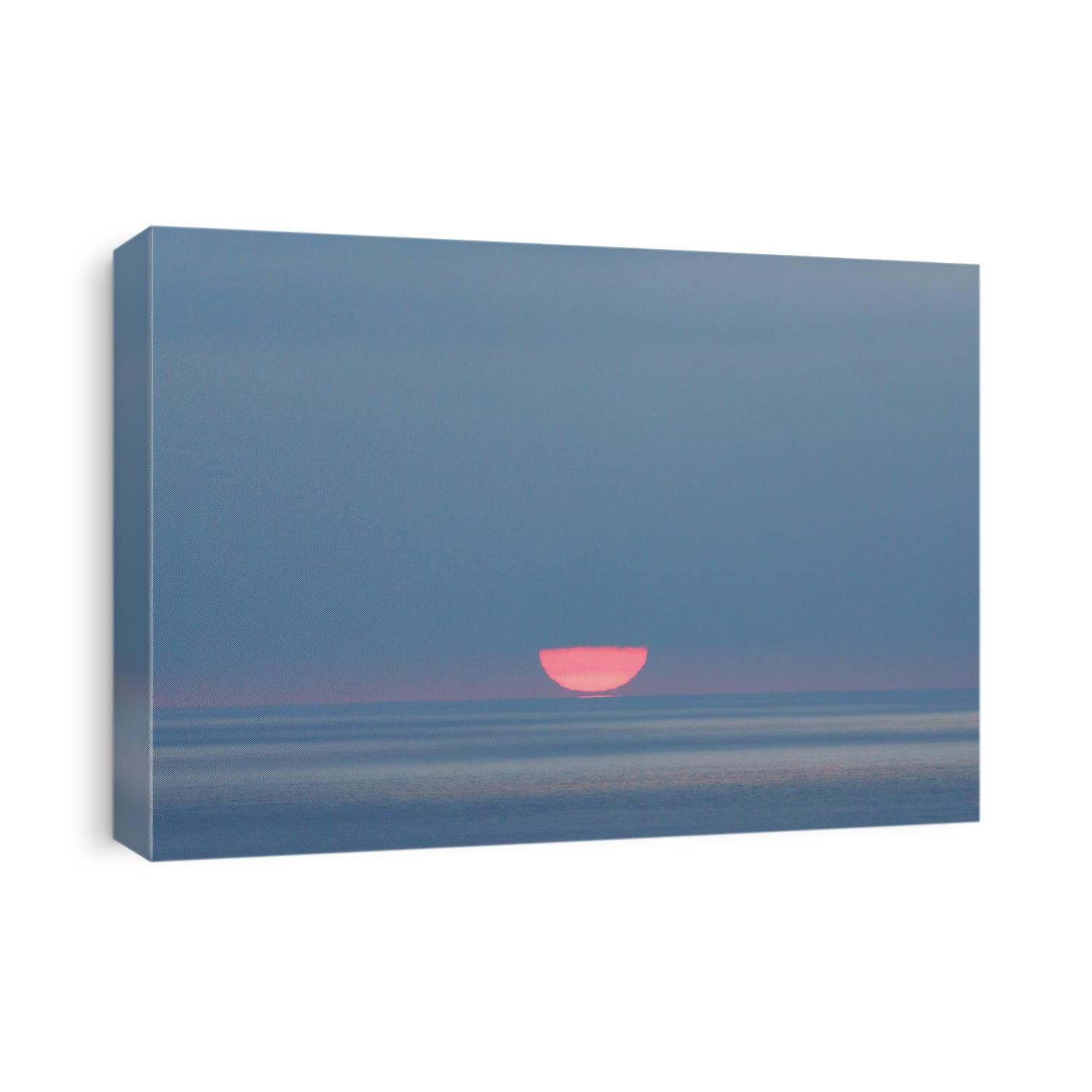 The sun appears to touch the horizon as the day turns into night