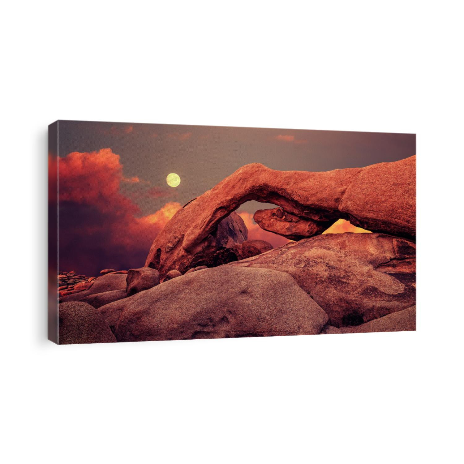 Purple sunset and rising moon over arch in Joshua Tree National Park, California, USA.