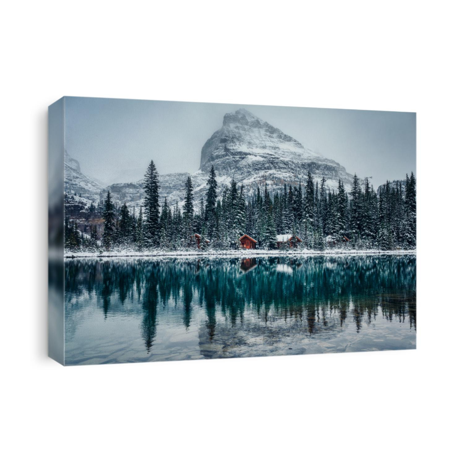 Wooden lodge in pine forest with heavy snow reflection on Lake O'hara at Yoho national park, Canada