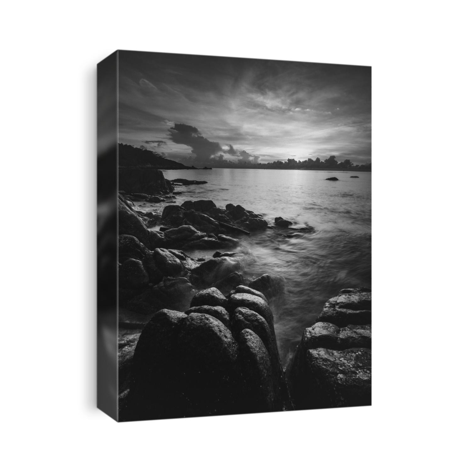 Island's dawn view at a peaceful rocky beach bay with dramatic sky and rock formation background. Long exposure with blurred tides and wave motion. Black and white. Koh Samui, Thailand.