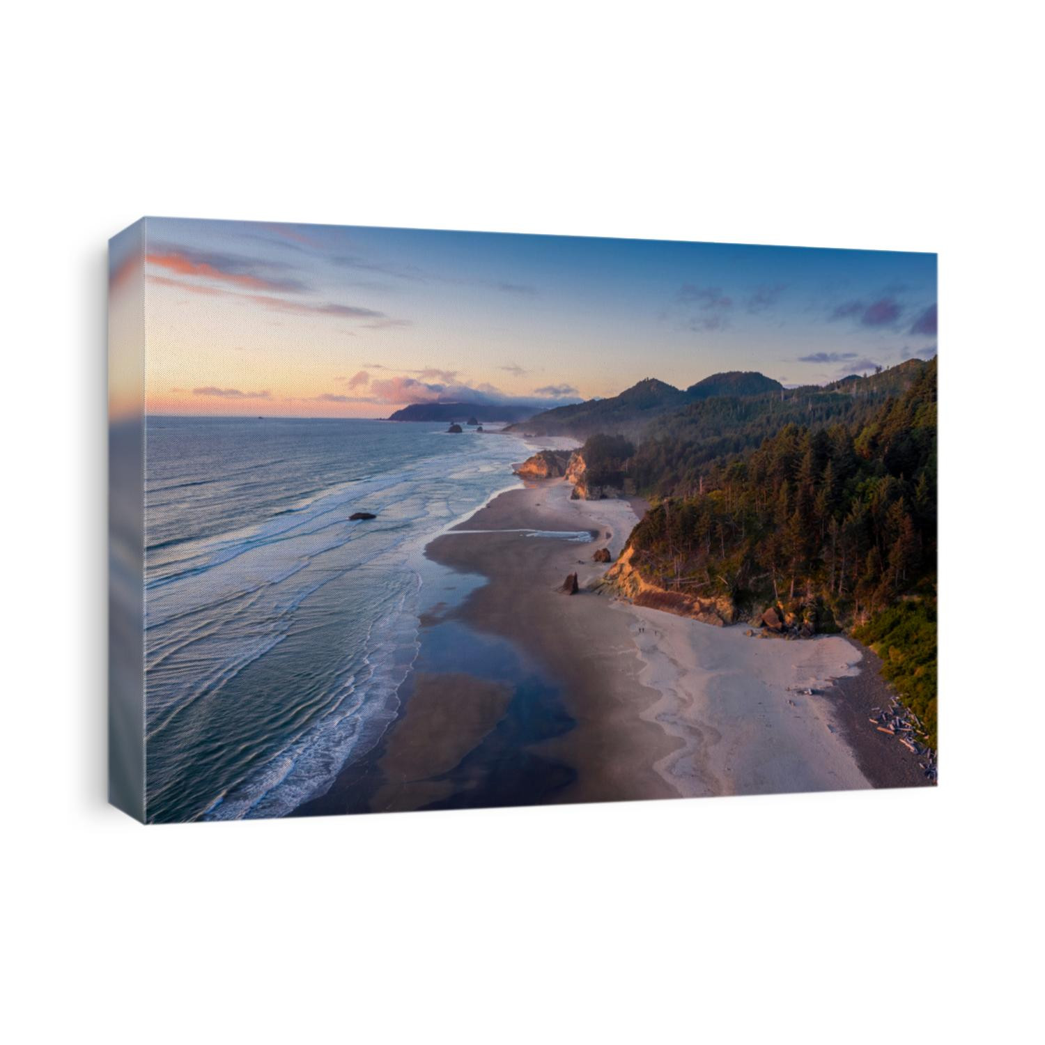 Aerial View of Arch Cape, Oregon. Sunset along the Oregon coast near Cannon Beach features white sand beaches with fir and cedar forests as far as the eye can see. 