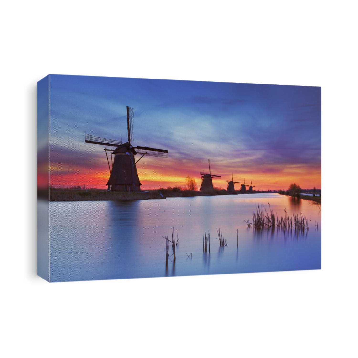 Traditional Dutch windmills with a colourful sky just before sunrise. Photographed at the famous Kinderdijk.