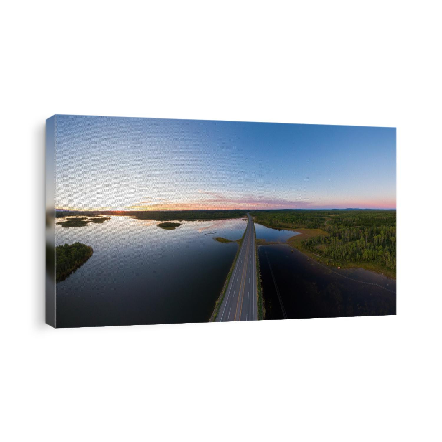 Picturesque Aerial View of Canadian Scenic Road surrounded by Peaceful Lakes. Vibrant summer sunset on the horizon. Cariboo Highway, Interior British Columbia.