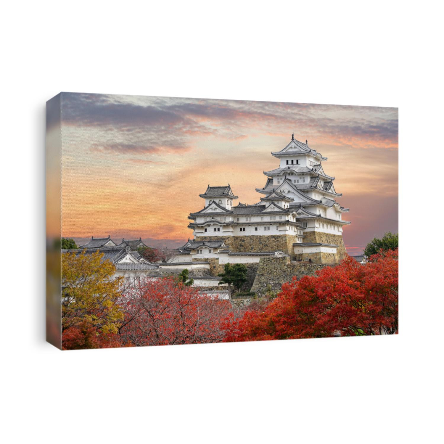 Himeji Castle and red maple leaves in evening sunlight and twilight sky in Himeji city, Hyogo prefecture of Japan.