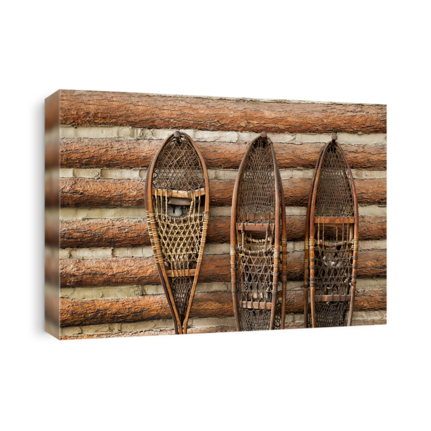 3 pairs of vintage snow shoes hanging on a cabin