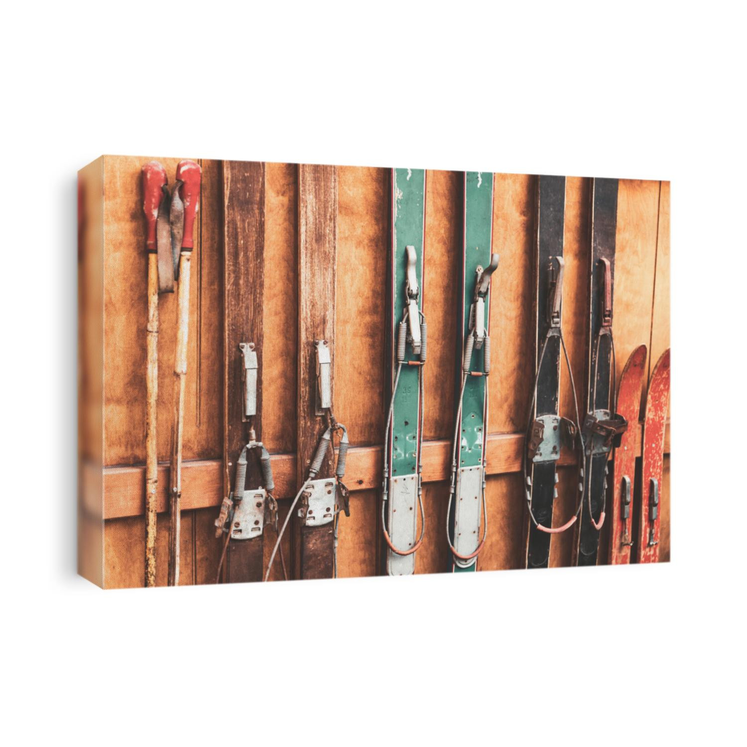 Collection of vintage wooden weathered ski's in front of an old barn